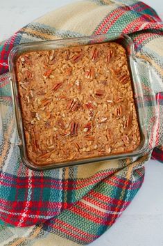 a casserole dish is sitting on a plaid cloth