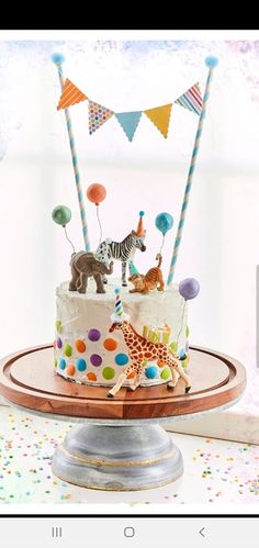 a birthday cake decorated with animals and balloons