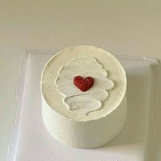 a white cake with a red heart on top