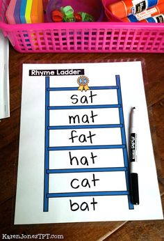 a pink basket filled with lots of toys next to a sign that says sat mat hat cat bat