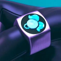 a close up of a purple and blue ring with a turtle on it's side