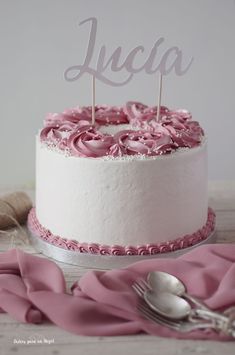 a white cake with pink frosting and a name on top