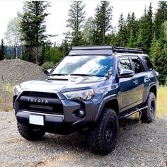 a black toyota truck parked on top of a dirt road