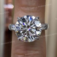 a woman's hand with a ring on it and a diamond in the middle