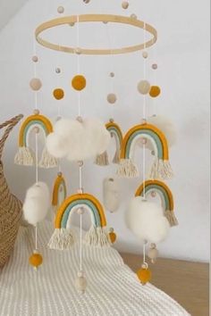 a crib mobile with rainbows and clouds hanging from it