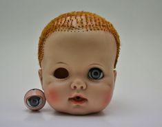 a doll head with an eyeball in the shape of a baby's head