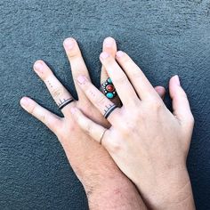 two people with rings on their fingers, one is holding the other's hand