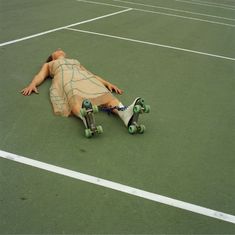 a man is laying on the ground with his skateboard in front of him,