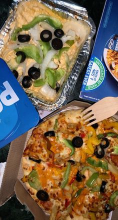 two pizzas with different toppings are on the table next to each other and one has a fork in it