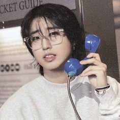 a young man holding two blue telephones to his ear