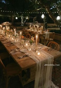 an outdoor dinner table set with candles and place settings