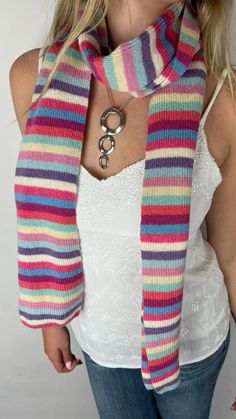 a woman wearing a multicolored striped scarf with an open circle pendant on her neck