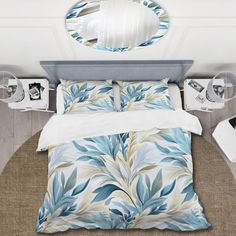 a bed with blue leaves on it and a round mirror above the bedspread