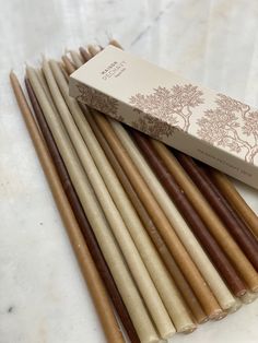 a box of brown and white sticks sitting on top of a table next to each other