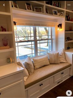 a window seat in the corner of a room with built - in bookshelves