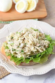 a chicken salad sandwich on a plate next to an egg