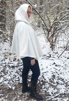 This short white cloak is delightfully soft and comfortable. It's long enough to reach the back of the hand, keeping you warm but keeping your hands available when needed. It has a full hood and closes with a matching cloth frog clasp. This cloak is great for a costume piece or a cozy jacket, great for Spring, Fall, and looks lovely over casual clothes or keeping you warm at a winter wedding. Your cloak will measure about 30 inches in length. This listing is in cream white, but other colors are White Long Sleeve Cape For Spring, White Long Sleeve Spring Cape, White Winter Poncho Cape, White Long Sleeve Cape For Fall, Hood Wedding, White Cloak, Cape With Hood, Short Blanc, Cozy Jacket