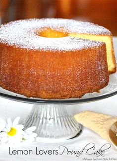 a lemon layer cake with powdered sugar on top sits on a glass platter