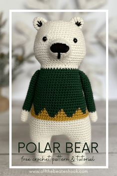 a crocheted polar bear wearing a green and yellow sweater with the words polar bear on it