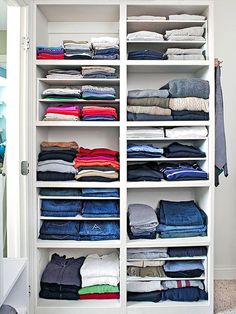 a closet filled with lots of folded clothes