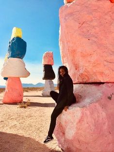 a woman sitting on top of a rock formation