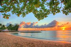 the sun is setting over the ocean and beach