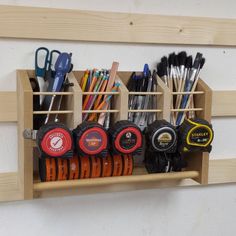 a wooden shelf with several different types of items on it and scissors in the holder