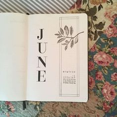 an open book with the word june written in black ink on top of floral fabric