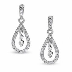 In all their formal elegance, these pear-shaped drop earrings are unsurpassed with magnificence and sparkle. Three diamonds embellish the center of each 10K white gold earring. Bringing the total weight to 1/3 ct., countless brilliant diamonds form a perfect outline around these remarkably striking friction back drops. Enjoy their beauty. Diamond Earrings Online, Back Drops, Buy Earrings Online, Gold Diamond Hoop Earrings, White Gold Earring, Gold Earrings For Women, Peoples Jewellers, Buy Earrings, Nickel Free Earrings