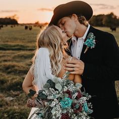 a bride and groom kissing in the field