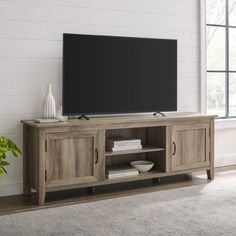 an entertainment center with a large flat screen tv on it's stand in front of a window