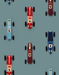 several toy cars are lined up in a row on a blue surface with black wheels