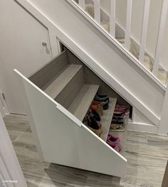 an under the stairs shoe rack with shoes in it