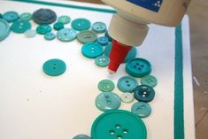 a bottle of glue is being used to decorate buttons