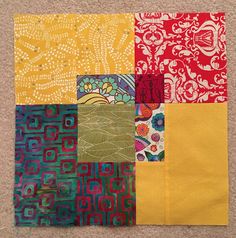 a patchwork quilt is laying on the floor with different colors and patterns in it