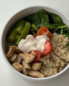 a white bowl filled with rice, meat and veggies covered in ranch dressing