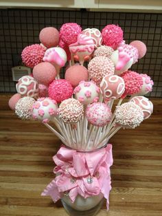 a vase filled with pink and white cake pops