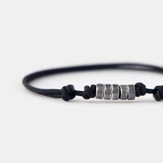 This men's beaded bracelet effortlessly combines a minimalist design with a touch of sophistication and masculinity, creating a captivating and unique piece. The combination of oxidizing surface and texture of handmade silver beads on the black cord catches the eye and adds a touch of personality to your style. With its lightweight and durable construction, this cord bracelet is designed for everyday wear. The adjustable cord ensures a comfortable and secure fit, making this minimalist bracelet a perfect accessory for your everyday adventures. D E T A I L S * 1.5 mm strong black nylon cord for comfortable everyday wear. * Oxidized sterling silver beads, approximately 5 mm. * Adjustable length with sliding knots. * Available in various sizes for a customized fit. * Designed in Barcelona. Al Everyday Silver Minimalist Wristband, Minimalist Silver Wristband For Everyday, Masculine Everyday Adjustable Bracelets, Minimalist Black Bracelet, Silver Minimalist Wristband, Minimalist Sliding Knot Bracelets, Modern Adjustable Wristband For Everyday, Modern Adjustable Wristband For Everyday Wear, Modern Adjustable Beaded Bracelets For Everyday