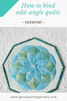 an image of a blue and green flower on a quilted wall hanging ornament