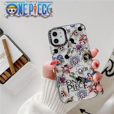 a woman holding up her phone case with mickey mouse and friends on it, next to some