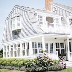 a large white house sitting on top of a lush green field