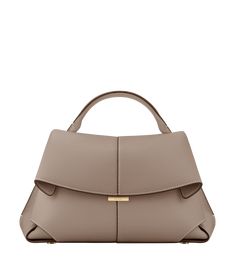 The "Mokki" model showcases the art of folding with its textured leather. The corners are cut to reveal smooth leather for a subtle interplay of textures. The bag’s interior is roomy and divided into compartments, all protected by a flap that features an engraved clasp. With its adjustable shoulder strap held in place by snap hooks, the model smoothly adapts to your movements. Taupe Purse, Handmade Leather Tote Bag, Modern Handbag, Micro Bags, Retro Fashion Women, Patterned Backpack, Quilted Handbags, Vegan Leather Bag, Best Wallet