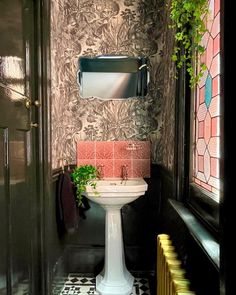 a bathroom with a pedestal sink and tiled floor