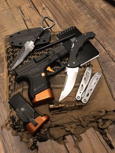 an assortment of knifes and knives laid out on top of a cloth with scissors