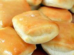 some bread rolls sitting on top of a cutting board next to each other with orange glaze