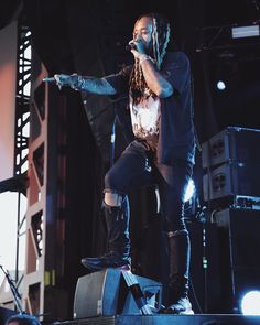 a man standing on top of a stage holding a microphone