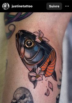 a tattoo on the side of a woman's leg with a fish and flowers