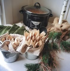 an assortment of utensils are sitting on a table next to a crock pot