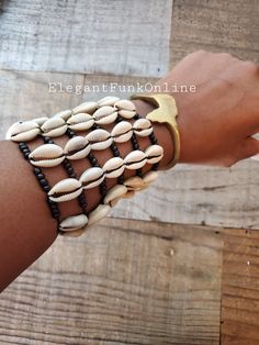 Am I the Drama? Don't pass on this unique yet beautiful tiered cowrie bracelet. Step up your arm game!! FUN FACTS: In Africa, and in the Americas, the cowrie symbolize destiny and prosperity and in many cases hold significant spiritual and even monetary value. The cowrie was an universal form of currency whose relevance weaved into the culture of Ancient African societies. (ref. Simon-Hartman.com) FEATURES ☆ Made with natural cowrie☆ Bracelet stretch to fit most wrists☆ Pairs great with any of o White Cowrie Shell Bracelet, Adjustable Cowrie Shell Bracelet, Adjustable Cowrie Shell Bracelet Jewelry, Adjustable Shell-shaped Bracelets For Festivals, Adjustable Bohemian Cuff Bracelet For Beach, Adjustable Bohemian Bracelets With Cowrie Shell, Adjustable Bohemian Beaded Bracelets With Cowrie Shell, Bohemian Beaded Cowrie Shell Bracelets, Bohemian Beaded Cowrie Shell Bracelet