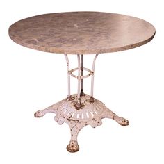 a round table with an iron base and marble top